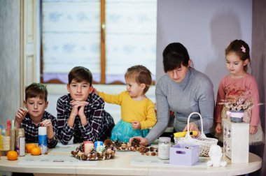 Dört çocuklu anne Noel arifesi için çelenk ve süsleme yapıyor. Yeni yıl kutlaması.