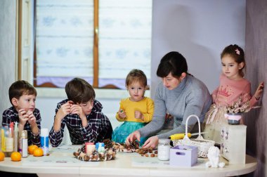 Dört çocuklu anne Noel arifesi için çelenk ve süsleme yapıyor. Yeni yıl kutlaması.