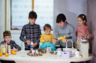 Dört çocuklu anne Noel arifesi için çelenk ve süsleme yapıyor. Yeni yıl kutlaması.