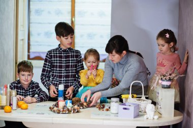 Dört çocuklu anne Noel arifesi için çelenk ve süsleme yapıyor. Yeni yıl kutlaması.