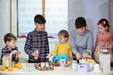 Dört çocuklu anne Noel arifesi için çelenk ve süsleme yapıyor. Yeni yıl kutlaması.