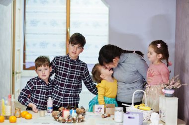 Dört çocuklu anne Noel arifesi için çelenk ve süsleme yapıyor. Yeni yıl kutlaması.