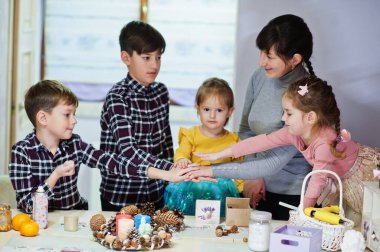 Dört çocuklu anne Noel arifesi için çelenk ve süsleme yapıyor. Yeni yıl kutlaması.