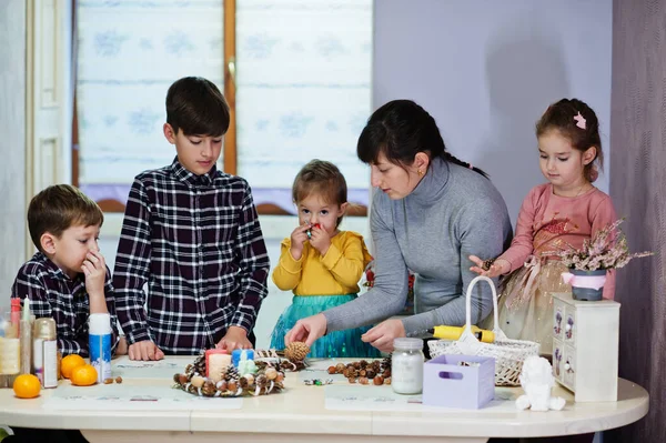 Dört çocuklu anne Noel arifesi için çelenk ve süsleme yapıyor. Yeni yıl kutlaması.
