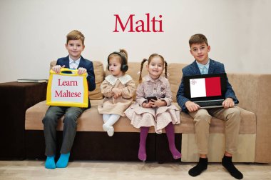 Dört çocuk yazıt gösteriyor. Malta lehçesi öğreniyorlar. Yabancı dil öğrenme konsepti. Malti Malta.