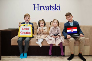 Dört çocuk yazıtlarda Hırvatça öğrendiklerini gösteriyor. Yabancı dil öğrenme konsepti. Hrvatski.