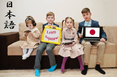 Dört çocuk yazıt gösterip Japonca öğreniyor. Yabancı dil öğrenme kavramı.