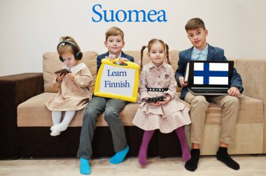 Dört çocuk yazıtları bitirmeyi öğreniyor. Yabancı dil öğrenme konsepti. Suomea.