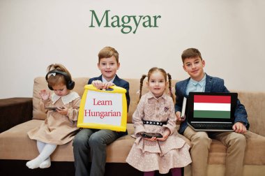 Dört çocuk yazıtlarda Macar dili öğreniyor. Yabancı dil öğrenme konsepti. Macar.