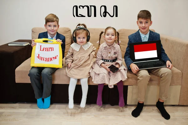 Dört çocuk yazıt gösterip, javaca öğreniyor. Yabancı dil öğrenme kavramı.