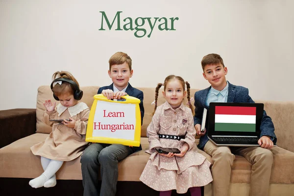 Dört çocuk yazıtlarda Macar dili öğreniyor. Yabancı dil öğrenme konsepti. Macar.