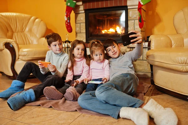 Щасливі Четверо Дітей Гаджетами Роблять Селфі Фото Вдома Біля Каміна — стокове фото