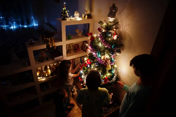 Kids Looking Christmas Tree Shining Garlands Evening Home — Zdjęcie stockowe
