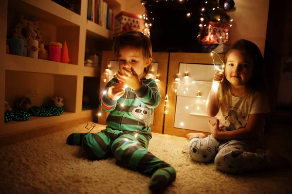 Dos Hermanas Bebé Mirando Árbol Navidad Con Guirnaldas Brillantes Casa — Foto de Stock