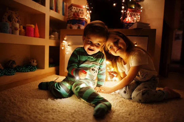 Two Baby Girl Sisters Looking Christmas Tree Shining Garlands Evening — Zdjęcie stockowe