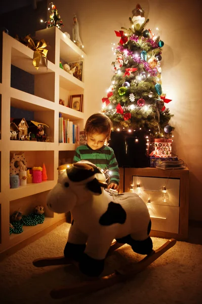 Baby Girl Rocking Cow Toy Christmas Tree Shining Garlands Evening — Foto de Stock