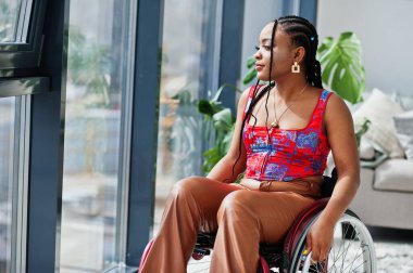 Engelli genç Afrikalı Amerikalı kadın tekerlekli sandalyede..