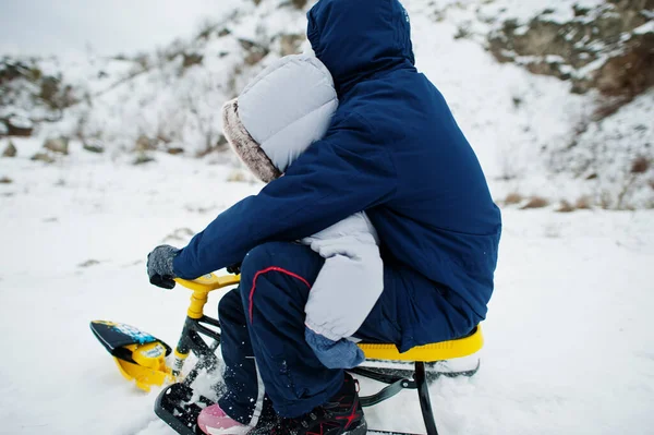 형제자매들은 썰매타기를 즐긴다 아동복이요 겨울에 썰매타는 — 스톡 사진