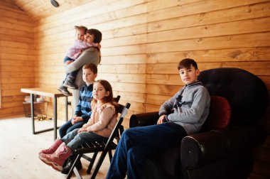 Anne ve çocuklar modern ahşap evde, sıcak ve sevgi içinde vakit geçiriyorlar..