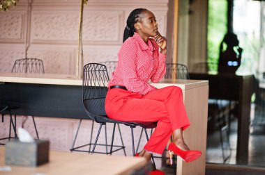 Pretty braids business african american lady bright bossy person friendly wear office red shirt and trousers, sitting on chair.