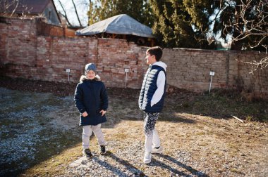 Güneşli bahar gününde yürüyen iki kardeş.