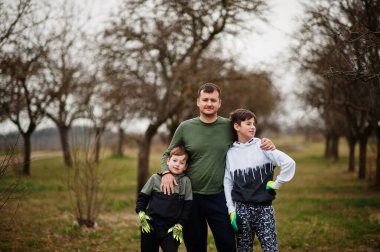 Bahar bahçesinde çalışan iki oğlu olan baba..