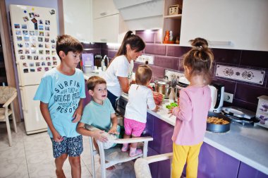 Anne ve çocuklar mutfakta yemek pişiriyor, mutlu çocuk anları..