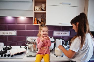 Anne ve kızı mutfakta yemek pişiriyor, mutlu çocuk anları..
