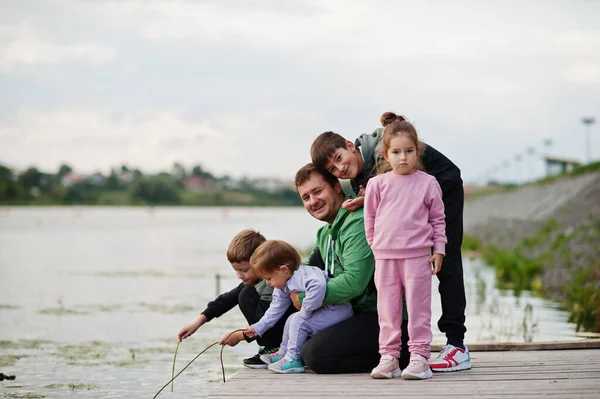 Baba sevgisi. Rıhtımda dört çocuklu bir baba. Büyük spor ailesi dışarıda vakit geçirir..