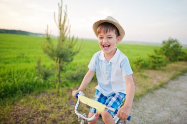 Çocuk bisikletle şapka takıyor, mutlu çocuk anları..
