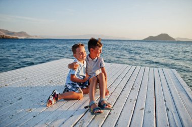 Türkiye 'de oturan iki kardeş Akdeniz' e karşı iskelede tatil yapıyorlar.