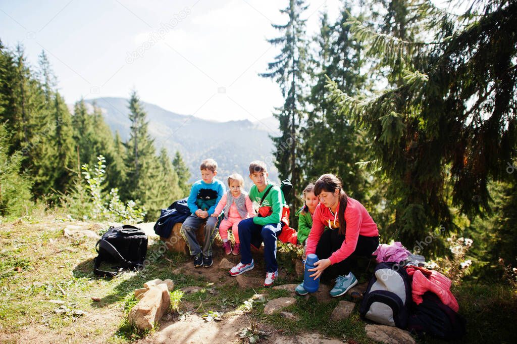 Mother with four kids resting in mountains. Family travel and hiking with childrens.