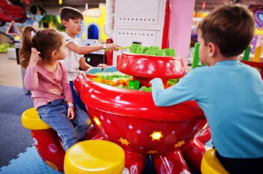 Çocuklar kapalı oyun merkezinde kinetik kumla oynuyorlar..