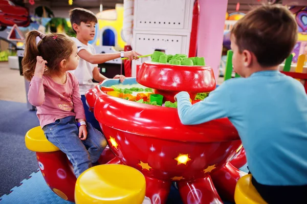 Kids play with kinetic sand in indoor play center.