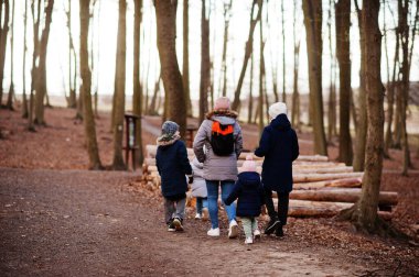 Dört çocuklu anneleri bahar ormanı başlarında ceket ve şapka giyer..