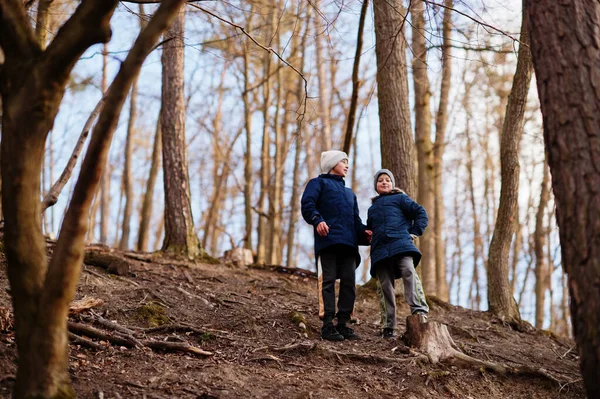 Bahar ormanlarında iki kardeş ceket ve şapka giyer.. 