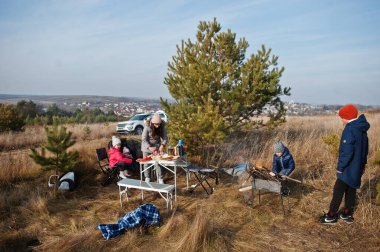 Çam ormanında bir güvertede aile barbeküsü. Izgarayla barbekü günü.