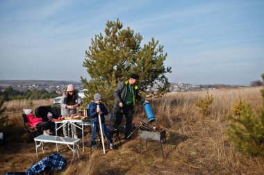 Çam ormanında bir güvertede aile barbeküsü. Izgarayla barbekü günü.