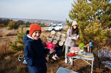 Çam ormanında bir güvertede aile barbeküsü. Izgarayla barbekü günü.