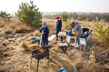 Çam ormanında bir güvertede aile barbeküsü. Izgarayla barbekü günü.