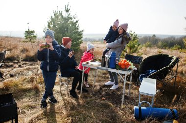 Çam ormanında bir güvertede aile barbeküsü. Izgarayla barbekü günü.
