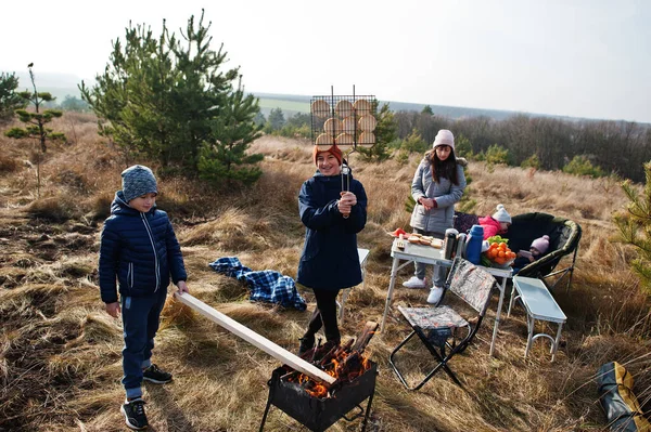Çam ormanında bir güvertede aile barbeküsü. Izgarayla barbekü günü.