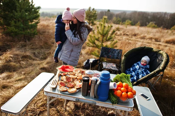 Çam ormanında bir güvertede aile barbeküsü. Izgarayla barbekü günü.