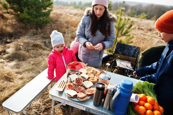 Çam ormanında bir güvertede aile barbeküsü. Izgarayla barbekü günü.