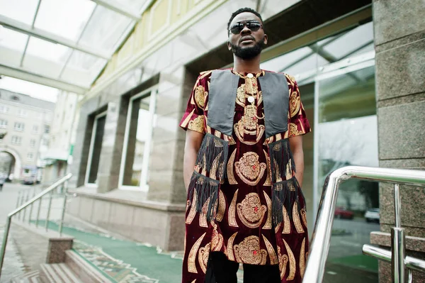 Geleneksel giysili ve güneş gözlüklü şık ve yakışıklı bir adam dışarıda bekliyor..