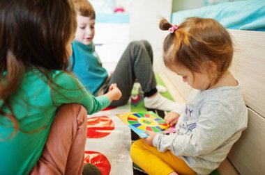 Mutlu bir aile birlikte eğleniyor, dört çocuk evde twister oynuyor..