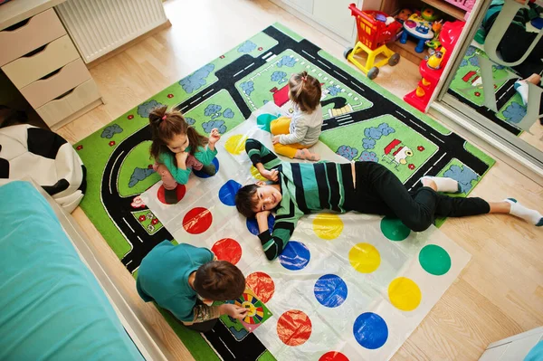 Mutlu bir aile birlikte eğleniyor, dört çocuk evde twister oynuyor..