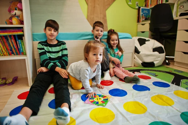 Mutlu bir aile birlikte eğleniyor, dört çocuk evde twister oynuyor..