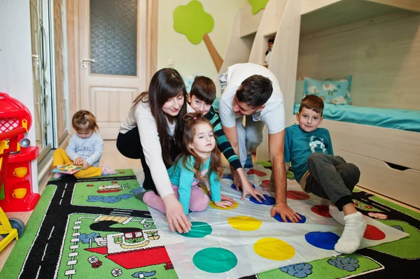 Mutlu büyük aile birlikte eğleniyor, dört çocuk evde twister oynuyor..