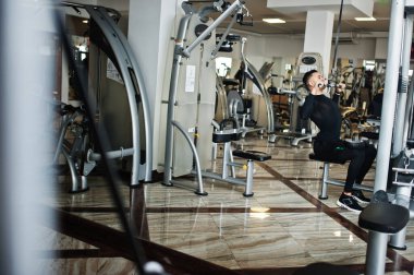 Modern spor salonunda spor yapan kaslı Arap adam spor yapıyor..